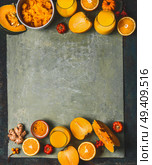 Orange color smoothie ingredients background for cold season: pumpkin, orange fruits, ginger, turmeric and persimmon fruits , top view, frame, copy space. Healthy mood and energy smoothie drinks. Стоковое фото, агентство Ingram Publishing / Фотобанк Лори
