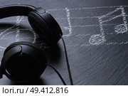 Music notes with  headphones on black stone background. Music notes with  headphones . Стоковое фото, агентство Ingram Publishing / Фотобанк Лори