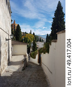 View of Granada street in the Realejo neighborhood with views of the Sierra Nevada and the Alhambra Palace. Andalusia, Spain. Стоковое фото, агентство Ingram Publishing / Фотобанк Лори