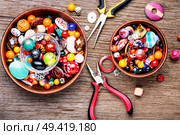 Jewelry making and beading process.Colored beads.Beaded jewelry. Colorful beads on a wooden surface. Стоковое фото, агентство Ingram Publishing / Фотобанк Лори