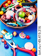 Jewelry making and beading process.Bead mix on blue background. Bead on blue background. Стоковое фото, агентство Ingram Publishing / Фотобанк Лори
