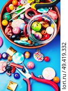 Jewelry making and beading process.Bead mix on blue background. Bead on blue background. Стоковое фото, агентство Ingram Publishing / Фотобанк Лори