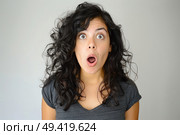 A woman displaying a surprised facial expression, her mouth open in shock or amazement. Стоковое AI-изображение, AI-художник Данила Большаков / Фотобанк Лори