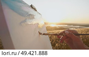 Using paintbrush and canvas, the young artist creates beautiful and atmospheric landscape that captures feeling of warm summer day. Стоковое видео, видеограф Strunov David / Фотобанк Лори