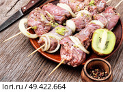 Fresh raw beef meat fillet shish kebab on skewers.Kiwi soaked meat. Raw shish kebab. Стоковое фото, агентство Ingram Publishing / Фотобанк Лори