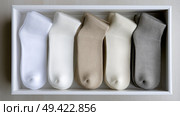 Five pairs of neatly organized socks displayed in a storage box. Пять пар аккуратно разложенных носков в коробке для хранения. Стоковое AI-изображение, AI-художник Katsiaryna Repich / Фотобанк Лори