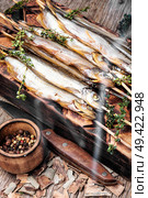 Smoked fish with spices.Cold smoked fish.Smoked capelin.Food industry. Smoked fish in a smoker. Стоковое фото, агентство Ingram Publishing / Фотобанк Лори