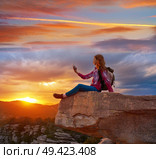 Hiker teen girl selfie smartphone on peak of mountain at sunset. Стоковое фото, агентство Ingram Publishing / Фотобанк Лори