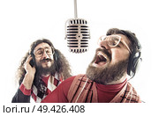 Two funny friends singing a karaoke. Стоковое фото, агентство Ingram Publishing / Фотобанк Лори