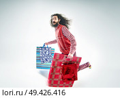 Nerdy guy holding a bunch of various shopping bags. Стоковое фото, агентство Ingram Publishing / Фотобанк Лори