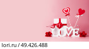 Valentines day background. Word Love, gift box, red ribbons and hearts lollipops. Festive greeting concept. Romantic Love declaration concept. Copy space for your design. Banner. Стоковое фото, агентство Ingram Publishing / Фотобанк Лори