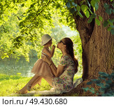 Brunette mother cuddling and kissing her beloved daughter. Стоковое фото, агентство Ingram Publishing / Фотобанк Лори