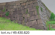 Osaka, Japan - Sep 22 2024, 4k, close up view of the old fortress wall covered with greenery consisting of large hewn stones, on the territory of Osaka Castle, Osaka, Japan. Стоковое видео, видеограф Сергей Богомяко / Фотобанк Лори
