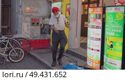 Osaka, japan - Sep 22 2024, 4k, A view of a dancing local weirdo in an alley next to vending machines, at night, in the Dotonbori district, Osaka, Japan. Редакционное видео, видеограф Сергей Богомяко / Фотобанк Лори