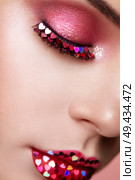 Face of Beautiful Woman with Holiday Makeup Heart. Valentine’s Day Make-up. Lips in Pink Lipstick. Makeup detail. Face of Girl on a Pink Background. Lashes Which are Glued with Hearts. Стоковое фото, агентство Ingram Publishing / Фотобанк Лори