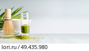 Matcha espresso in glass with whisk on table at light background, front view with copy space. Template or banner.  Clean eating, detox beverage, healthy dairy food concept. Antioxidant boost drink. Стоковое фото, агентство Ingram Publishing / Фотобанк Лори