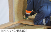 Insulation of a frame house with mineral wool. Cutting, fitting, laying insulation. Construction works. Стоковое видео, видеограф Константин Мерцалов / Фотобанк Лори
