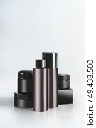 Black and brown cosmetic product jars and bottles with branding mock up, standing on light table at wall background. Snail mucin cosmetic set or charcoal cosmetics. Modern facial skin care. Copy space. Стоковое фото, агентство Ingram Publishing / Фотобанк Лори