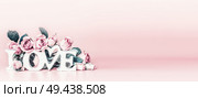 Abstract love concept with word love and pastel pink roses at trendy muted colors background. Creative romantic  layout. Wedding card. Copy space. Banner or template. Стоковое фото, агентство Ingram Publishing / Фотобанк Лори