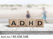 ADHD sign on a wooden table with kids acting wild in the background. Стоковое фото, агентство Ingram Publishing / Фотобанк Лори