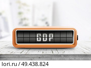 GDP announcement on a retro device in a bright office with a wooden desk. Стоковое фото, агентство Ingram Publishing / Фотобанк Лори