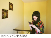 Beautiful brunette woman in a yellow room in her home                                . Стоковое фото, агентство Ingram Publishing / Фотобанк Лори