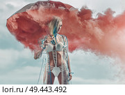Conceptual portrait of a blond lady holding smoky umbrella. Стоковое фото, агентство Ingram Publishing / Фотобанк Лори