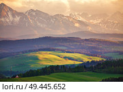 Snow caped mountains and green fields and meadows in Malopolska region, Poland. Spring sunset in Tatra Mountains, Pieniny range. Стоковое фото, агентство Ingram Publishing / Фотобанк Лори