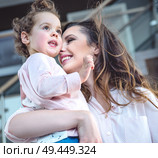 Portrait of a cheerful mom cuddling beloved daughter. Стоковое фото, агентство Ingram Publishing / Фотобанк Лори
