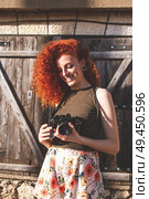 Young redhead photographer woman enjoying her passion outdoors. Стоковое фото, агентство Ingram Publishing / Фотобанк Лори