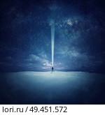 Milky Way night sky with stars and silhouette of a standing alone man in the middle of a sandy desert, pointing up the lantern light, trying to find a specific star. Стоковое фото, агентство Ingram Publishing / Фотобанк Лори