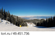 Slope on the skiing resort in Bansko, Bulgaria. Snow fir forest and clear blue sky. Стоковое фото, агентство Ingram Publishing / Фотобанк Лори