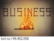 Burning match setting fire to its neighbors in arranged in shape of business word. Ignited match stick  as a symbol for business risks and dangers. Стоковое фото, агентство Ingram Publishing / Фотобанк Лори