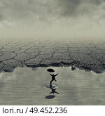 Surrealistic image with a boy jumping in a pothole of cracked asphalt in a rainy day. Broken pavement with a dirty water puddle in a imaginary town. Стоковое фото, агентство Ingram Publishing / Фотобанк Лори