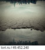 Surrealistic image with a city reflect in a pothole of cracked asphalt. Broken pavement with a dirty water puddle. Стоковое фото, агентство Ingram Publishing / Фотобанк Лори