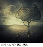 Surreal background as a bizarre pear tree with a big rock instead of the leaves crown, placed in the middle of a cracked desert ground of another planet. Стоковое фото, агентство Ingram Publishing / Фотобанк Лори