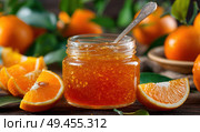 A jar of orange jam is sitting on a table with a spoon and several oranges. Стоковое AI-изображение, AI-художник Ярославский Максим / Фотобанк Лори
