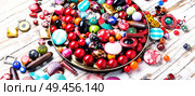 Jewelry making.Variety of shapes and colors to make bead necklace. Colorful beads on wooden surface. Стоковое фото, агентство Ingram Publishing / Фотобанк Лори