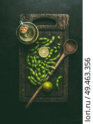 Green edamame soybeans on wooden cutting board with cooking spoon , top view. Healthy vegetarian food. Стоковое фото, агентство Ingram Publishing / Фотобанк Лори
