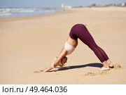 Caucasian woman practicing yoga at seashore. Young female doing downward-facing dog in the beach in Cadiz, Andalusia, Spain.. Caucasian blonde woman practicing yoga in the beach. Стоковое фото, агентство Ingram Publishing / Фотобанк Лори