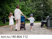 A family with three children. A mother with many children and toddlers in a summer park. Children are walking in the fresh air. Having many children and family values. Стоковое фото, фотограф Photojuli / Фотобанк Лори