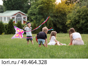 A family with three children. A mother with many children and toddlers in a summer park. Children are walking and flying a kite. Large families, family values, and leisure time with children. Стоковое фото, фотограф Photojuli / Фотобанк Лори