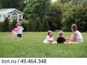 A family with three children. A mother with many children and toddlers in a summer park. Children are walking and flying a kite. Large families, family values, and leisure time with children. Стоковое фото, фотограф Photojuli / Фотобанк Лори