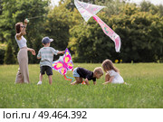 A family with three children. A mother with many children and toddlers in a summer park. Children are walking and flying a kite. Large families, family values, and leisure time with children. Стоковое фото, фотограф Photojuli / Фотобанк Лори