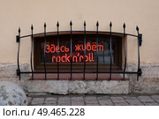 Неоновая надпись «Здесь живёт rock'n'roll» за решеткой. Редакционное фото, фотограф Пучков Андрей Александрович / Фотобанк Лори
