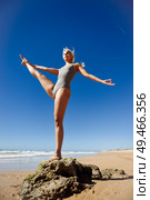 Caucasian woman practicing yoga at seashore. Young female standing on one leg while practicing the tree pose on a tranquil beach in Cadiz, Andalusia, Spain.. Caucasian blonde woman practicing yoga in the beach. Стоковое фото, агентство Ingram Publishing / Фотобанк Лори