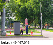 Двое рабочих у электрического шкафа на городской улице. Ремонт светофора. Редакционное фото, фотограф Мария Сергеева / Фотобанк Лори