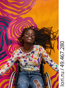 A woman sitting in a wheelchair positioned in front of a vibrant and colorful wall. Стоковое AI-изображение, AI-художник Данила Большаков / Фотобанк Лори