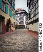 Narrow streets of the old city Strasbourg with idyllic timber framed facades of medieval buildings. Beautiful fachwerk germanic architecture Petite France district, Alsace. . Стоковое фото, агентство Ingram Publishing / Фотобанк Лори