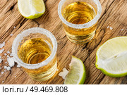 Alcoholic drinks on rustic wood background.Gold tequila with salt and lime. Tequila on table. Стоковое фото, агентство Ingram Publishing / Фотобанк Лори